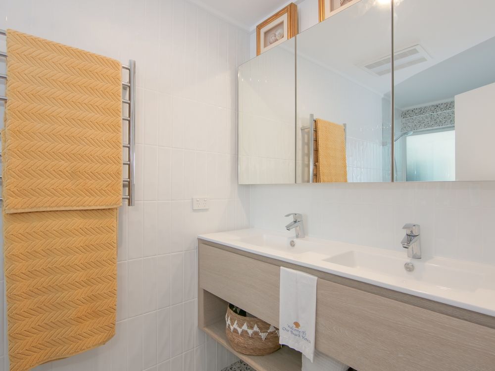 Bathroom with double sinks, shower and toilet