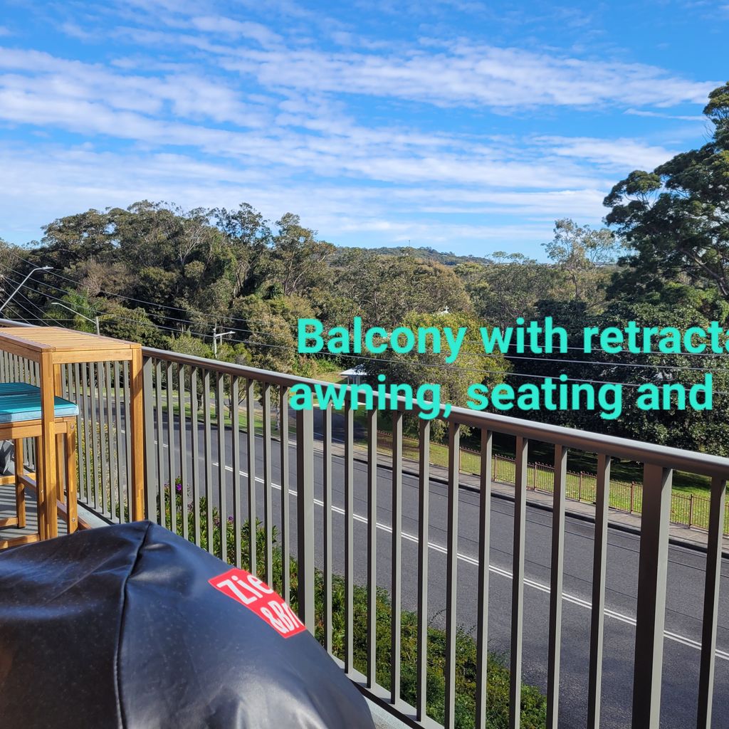 Outdoor set and BBQ in foreground.