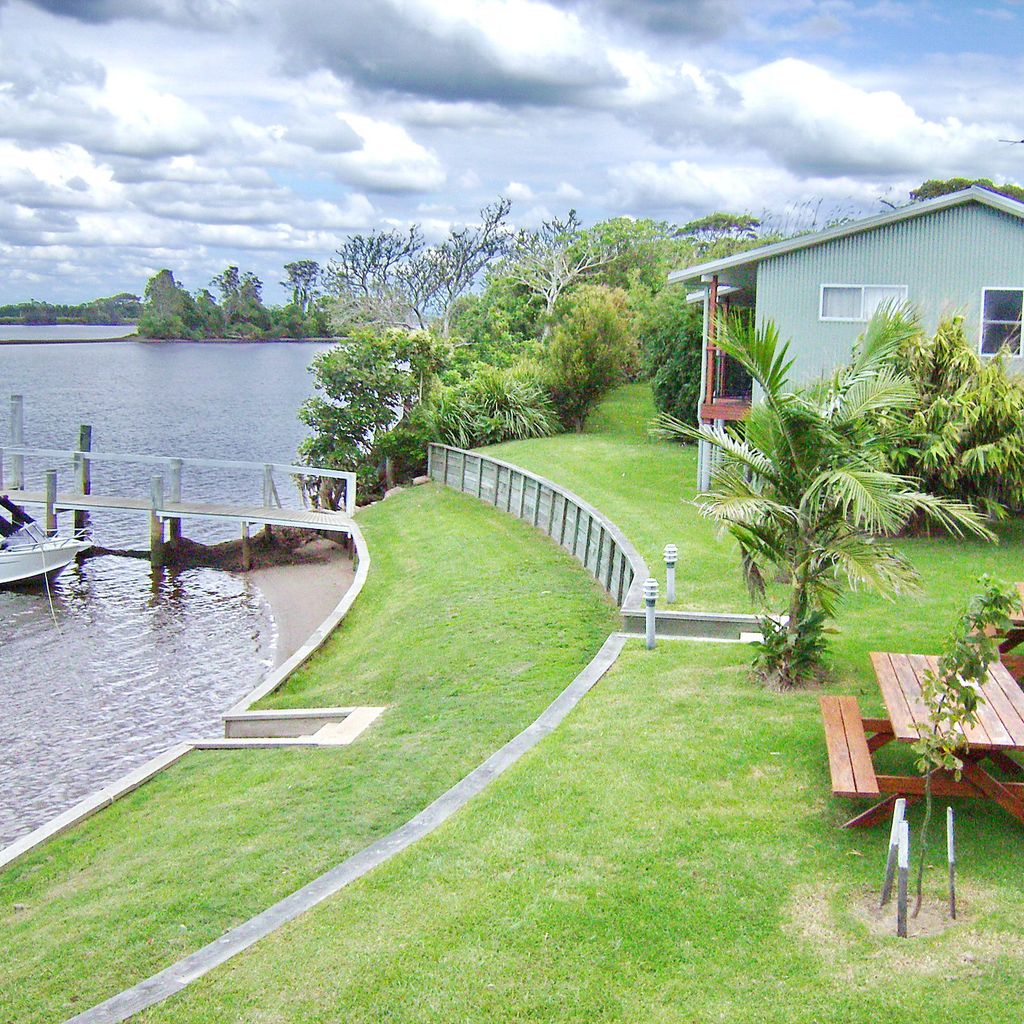 Riverfront with pier and outdoor seating.