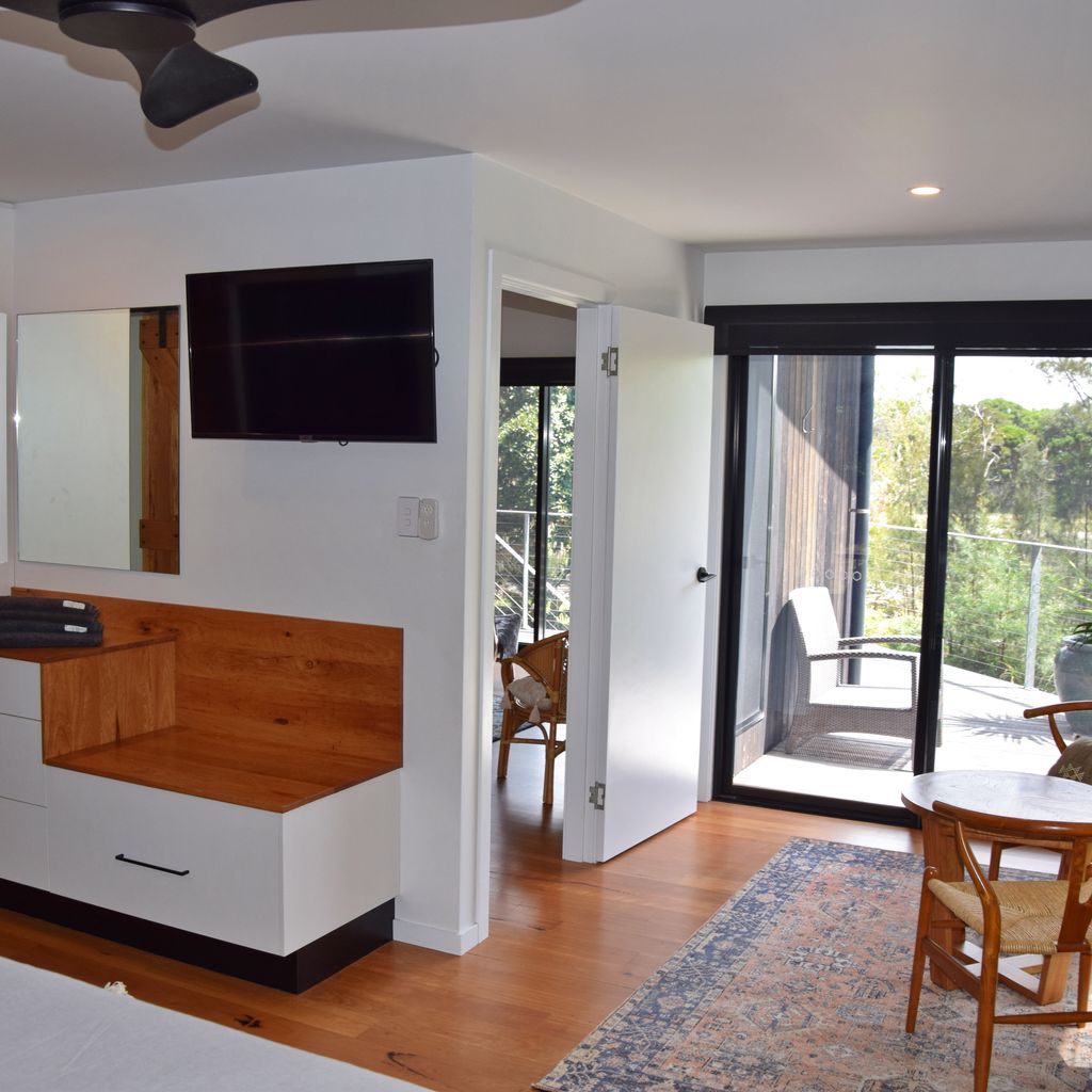 Master bedroom alternate angle with balcony and TV.