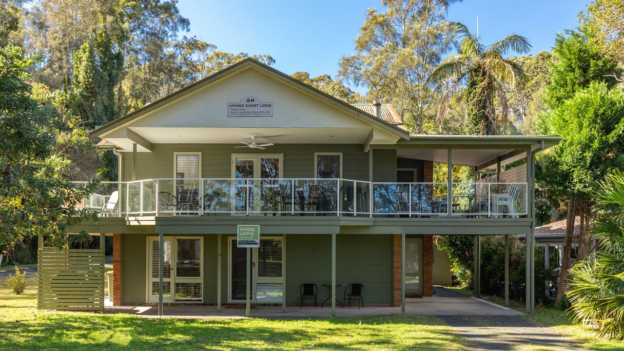 House Exterior with Balcony and Lawn