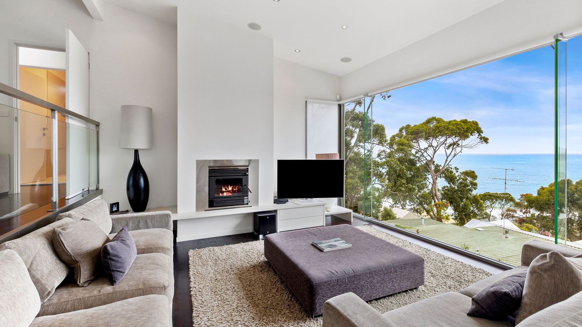 The upstairs living room has stylish furnishings and a fireplace to keep you cosy. 