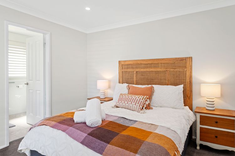 Bedroom 1, the master bedroom, has a Queen bed, a walk-in robe, ceiling fan, air-conditioning, and an ensuite with a full-body rain shower, toilet, and a hair dryer.