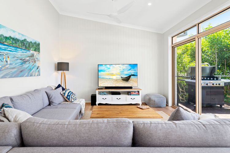 The living room opens to a balcony with the beautiful sight of lush green foliage surrounding the property.