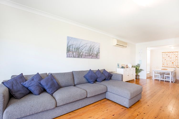 Beautiful light filled living area with combustion fireplace and huge couch
