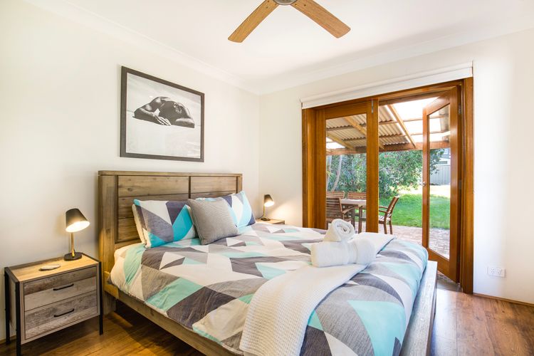 Queen bedroom with doors opening onto patio