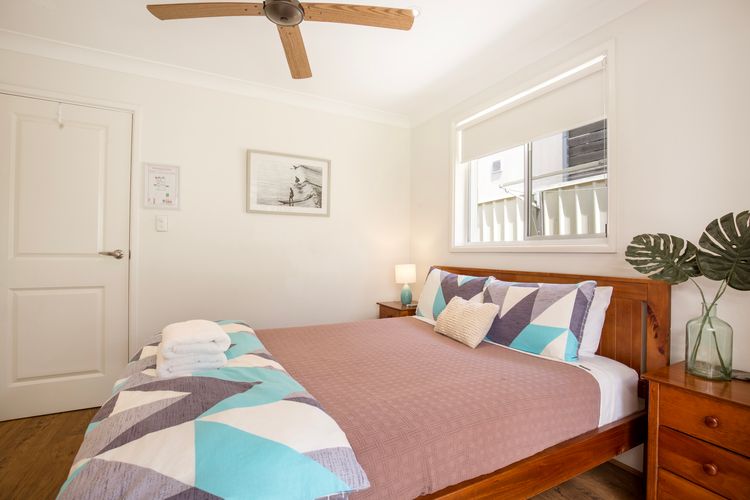 Queen bedroom with double doors that open onto rear patio