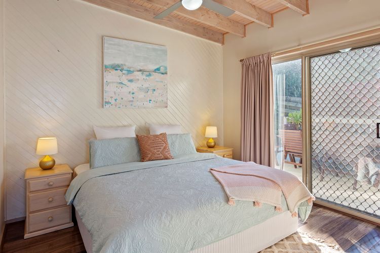 Bedroom 1: King bed, built-in robe, and courtyard access.