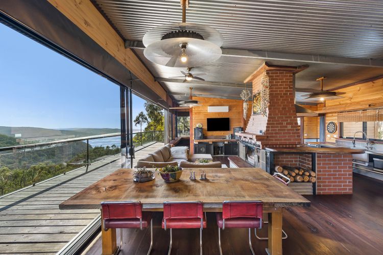Rustic open plan dining, lounge and kitchen opens onto the balcony