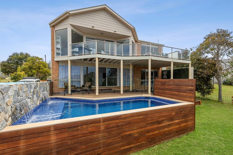 A private swimming pool is nestled on a large lawn, ideal for having fun at anytime of day.