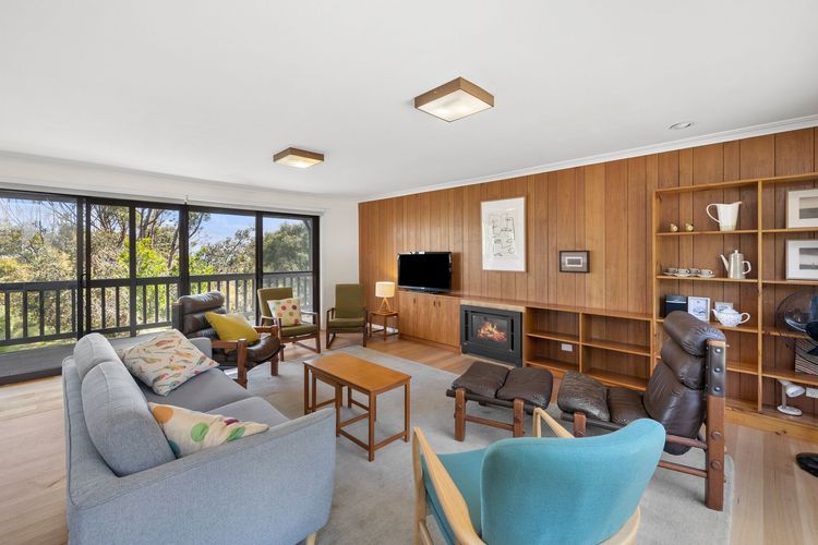 A stylish and elegant living room welcomes you. It has timber floors complemented by wooden shiplap walls. Adding to its artsy and cosy vibe, it has mismatched lounge chairs and couches, coloured throw pillows, Wi-Fi, and a flat-screen TV.