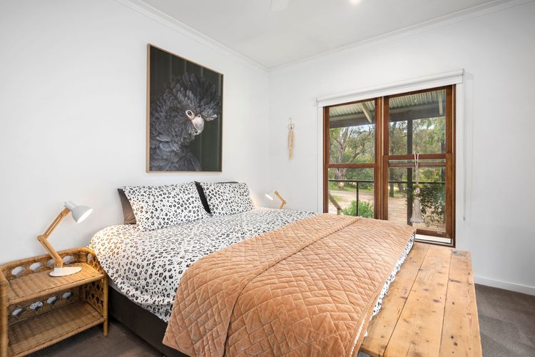 The Master bedroom has a Queen bed and a ceiling fan. The way the light pink blanket contrasts with the bedsheets' striking cheetah print makes it look bold and fun. It also comes with an ensuite with a shower, toilet, toilet paper, and vanity.