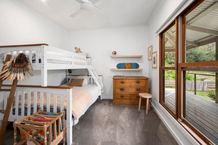 Bedroom 2 has a Tri-bunk bed with a ceiling fan and a walk-in robe. Your teen kids would probably enjoy this room, as it has accents of a study table and a surfboard. It also opens to the porch, so they can enjoy the view any time of the day.