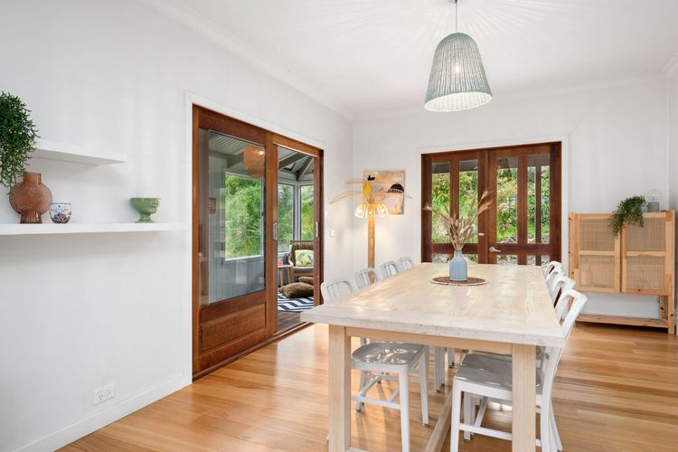 The dining set plays with white chairs and an ivory wood-stain table. The side rustic walnut stain-wood doors add sophistication to the dining area.