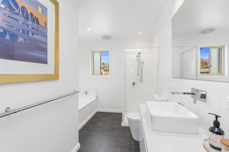 The bathroom has a shower, a bathtub, and a separate toilet.