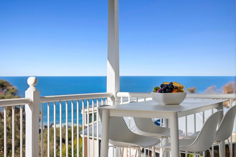 Outdoor deck with a peaceful blue water outlook.