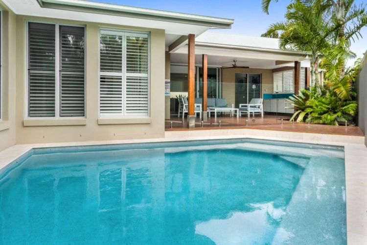 Walk a few steps to the rear of the house to see an expansive outdoor lounge suite that faces a swimming pool.