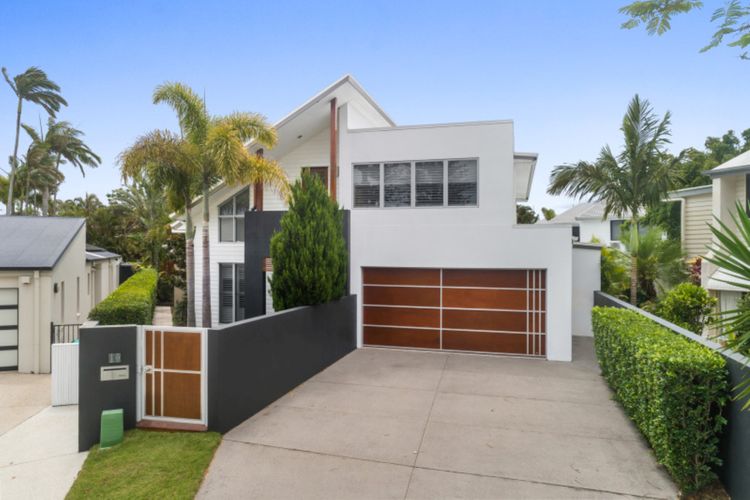 A landscaped lawn, a beautiful garden, and lush bushes welcome you to the property.