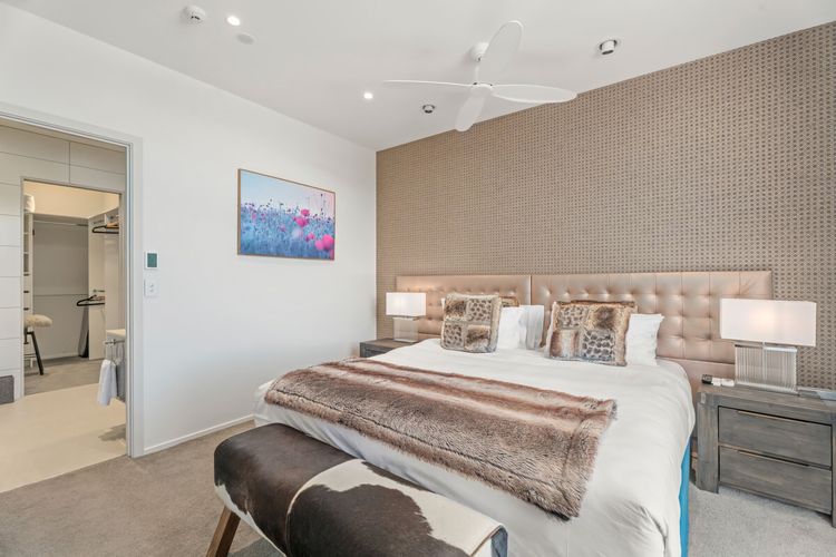 One of three spacious bedrooms with balcony access, lake views, ensuite and walk-in wardrobe.