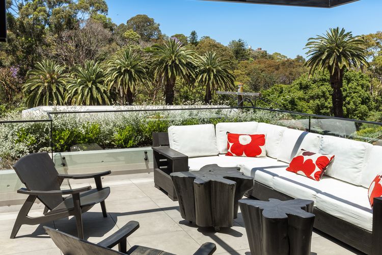 Alfresco terrace with retractable glass roof, plush outdoor seating and sweeping treetop views.