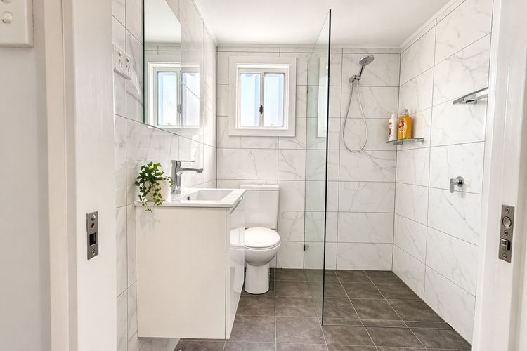 A clean, modern bathroom with both shower and toilet