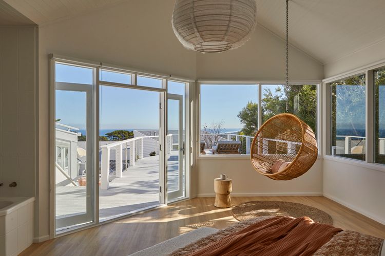Bedroom seven with hanging chairt and large balcony with sun loungers 