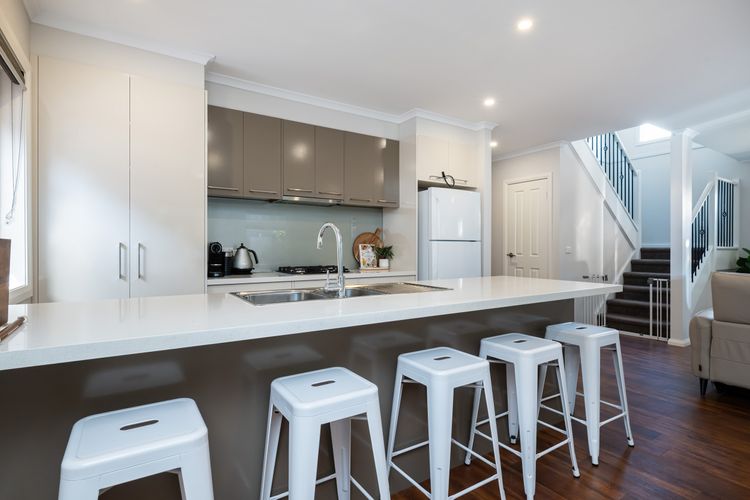 Fully equipped kitchen with breakfast bench and seating for five.