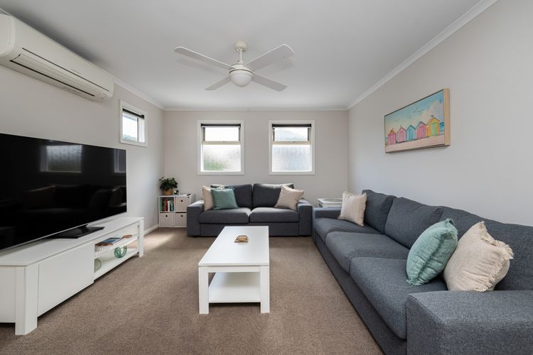 Upstairs living area featuring smart TV, comfy couches and a split system.