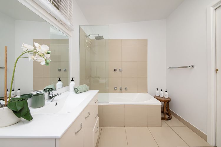 Spacious bathroom/ laundry with shower over bath / toilet and washing machine
