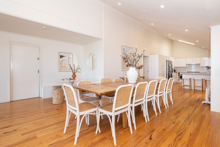 A spacious dining table takes center stage, adorned with tasteful decor.