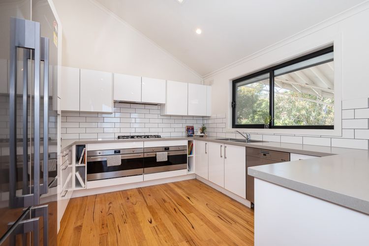 The kitchen, a chef's dream, features modern appliances and sleek countertops, providing ample space for meal preparation and culinary creations. 