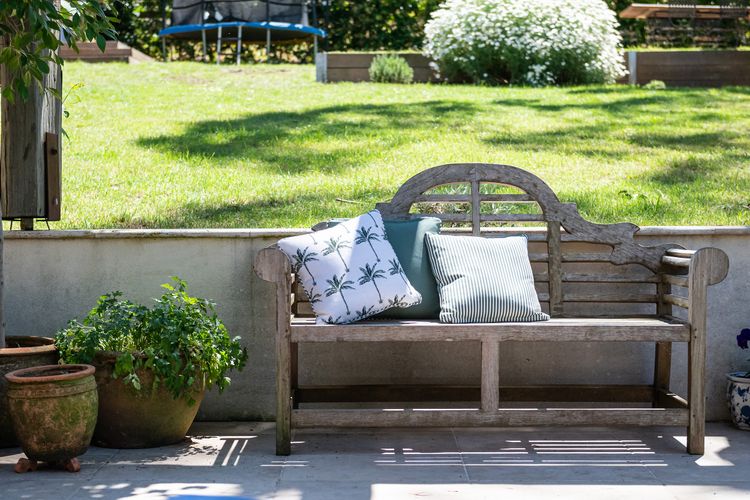 Enjoy the outdoor furniture, which offers a picturesque setting against the backdrop of lush greenery.