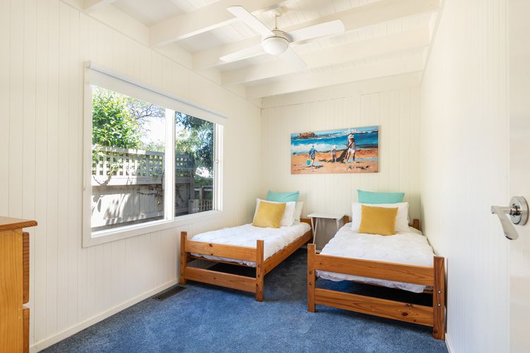 Bedroom four has 2 single beds and a ceiling fan
