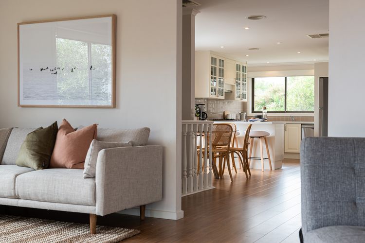 Comfy sofa with a peak of the kitchen and dining