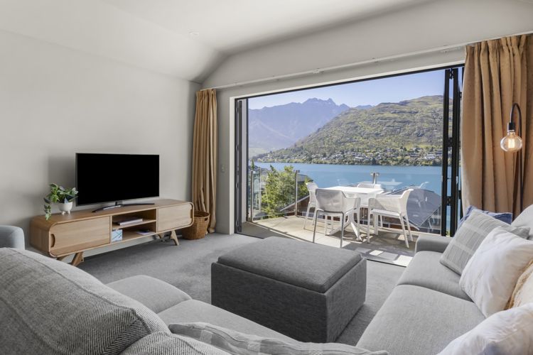 Living room with balcony and lake and mountain views