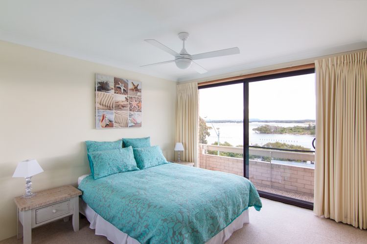 Master bedroom opening onto balcony with lake views