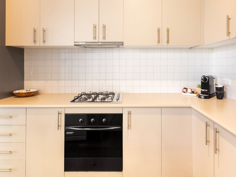 Kitchen prep counter featuring a built-in stovetop, oven, and ample storage cabinets.