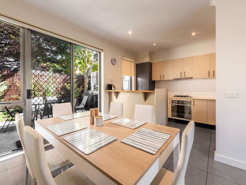 Bright indoor dining space situated near sliding glass doors overlooking the outdoor area.