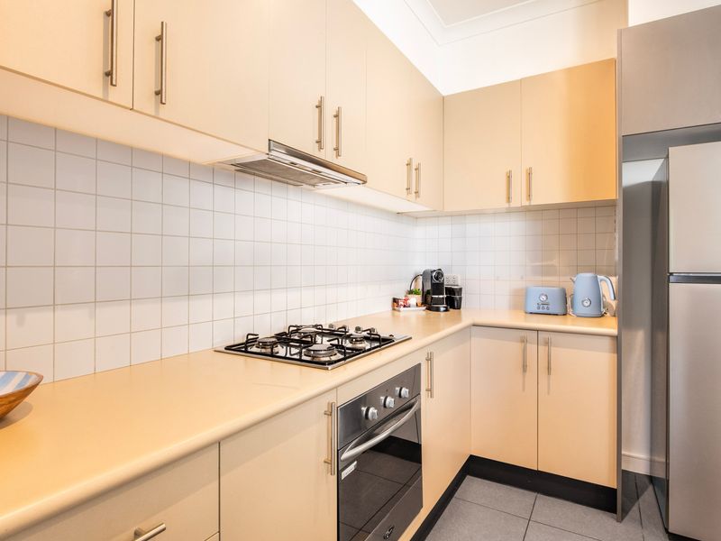 Modern kitchen equipped with light wooden cabinetry, a built-in oven, and a gas stovetop.