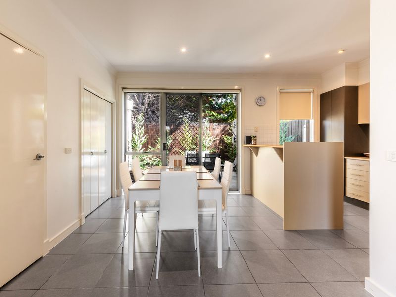 Interior hallway and dining transition showcasing contemporary flooring and bright lighting.