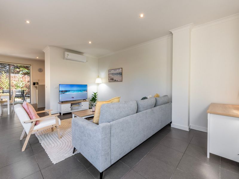 Contemporary lounge area with a light gray sofa and modern interior lighting.