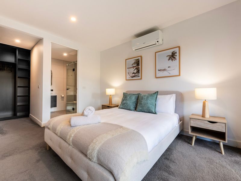 Comfortable bedroom with soft bedding and bedside lamps