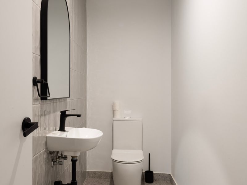 Additional bathroom view focusing on a minimalist white basin counter and toilet.