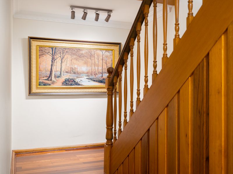 Wooden staircase railing detail leading upstairs.