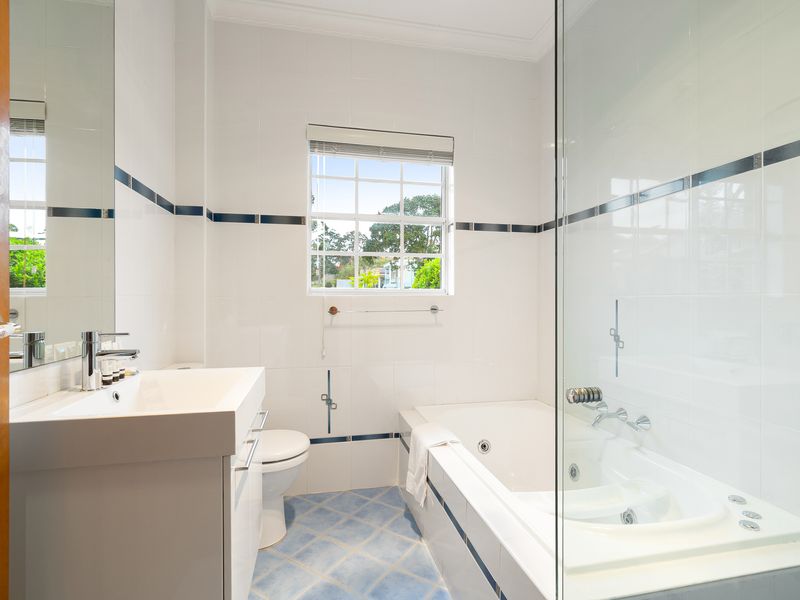 Modern bathroom with a glass shower enclosure and bathtub.