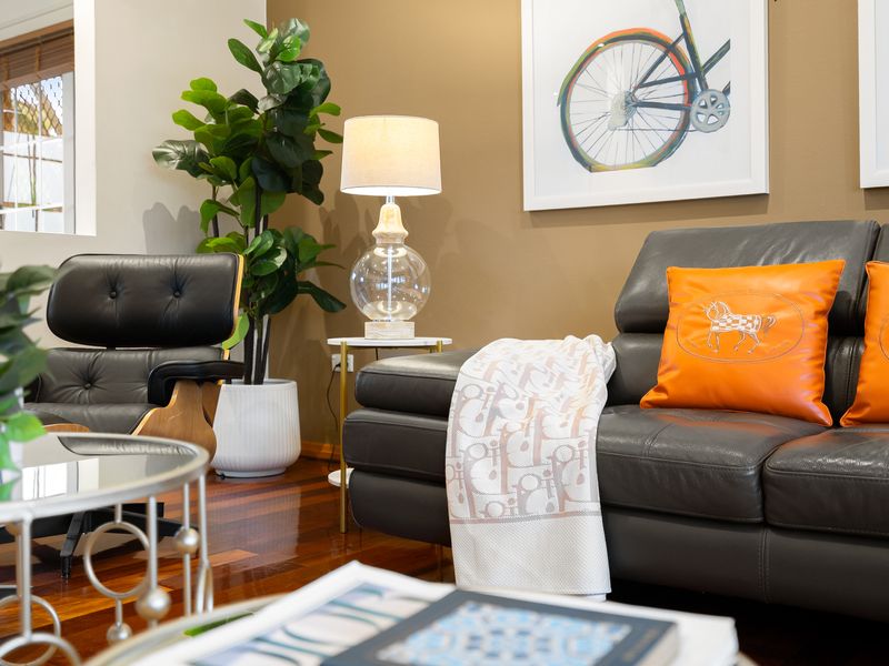Alternative view of the living area showcasing a dark sofa and modern decor.
