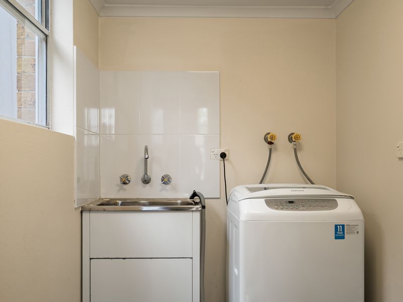 Functional laundry area with a washing machine and utility sink.