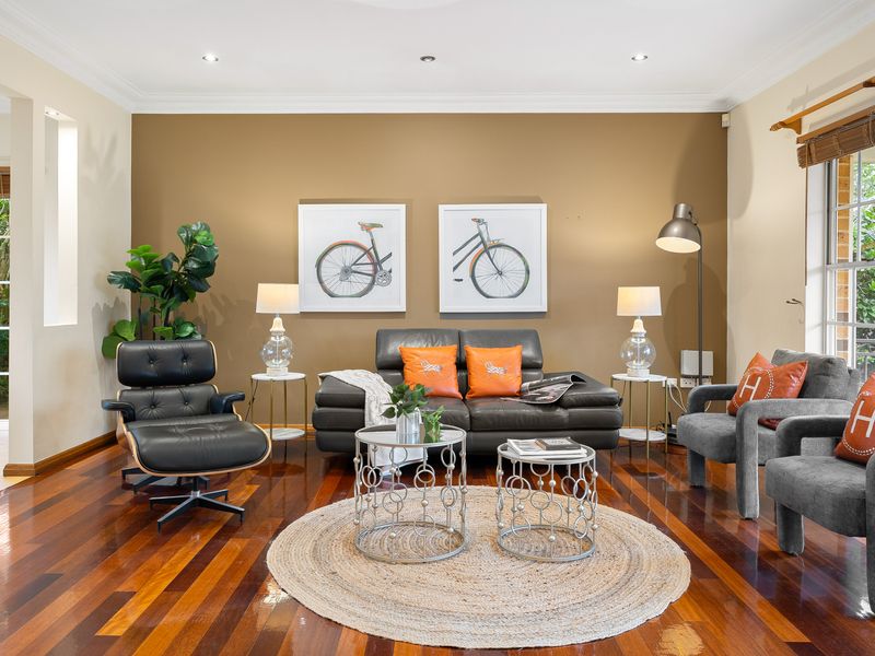 Open-plan living and dining space featuring modern wooden flooring and art pieces.
