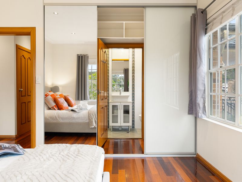 Cozy bedroom featuring orange accent pillows and framed wall art.
