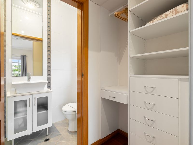 Compact bathroom vanity mirror cabinet and white sink unit.